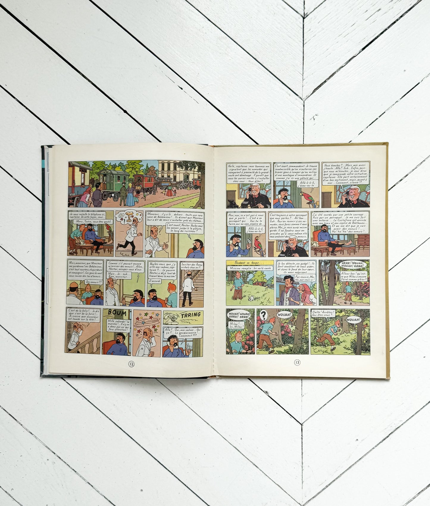 Open comic book on a white wooden floor
