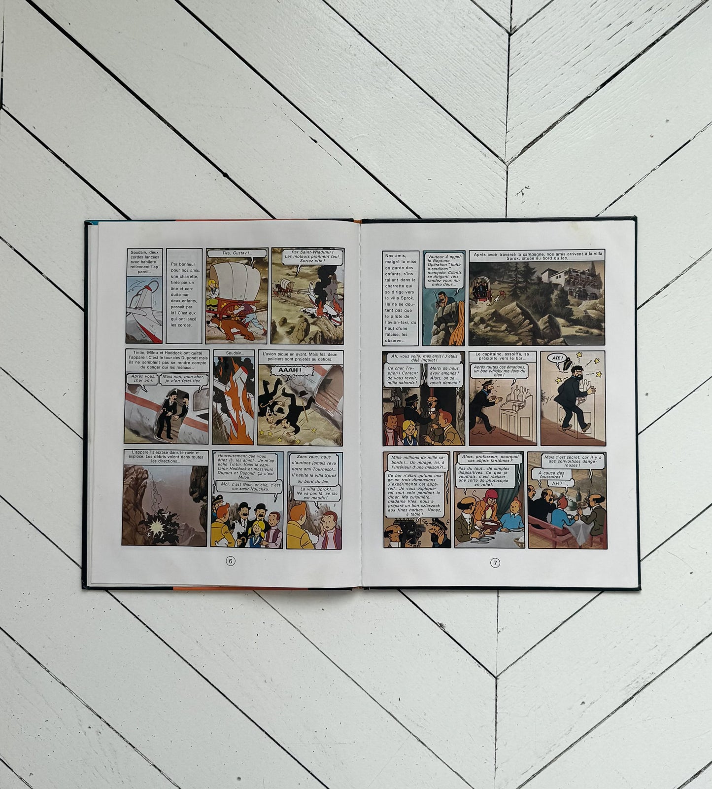 Open comic book on a white wooden floor