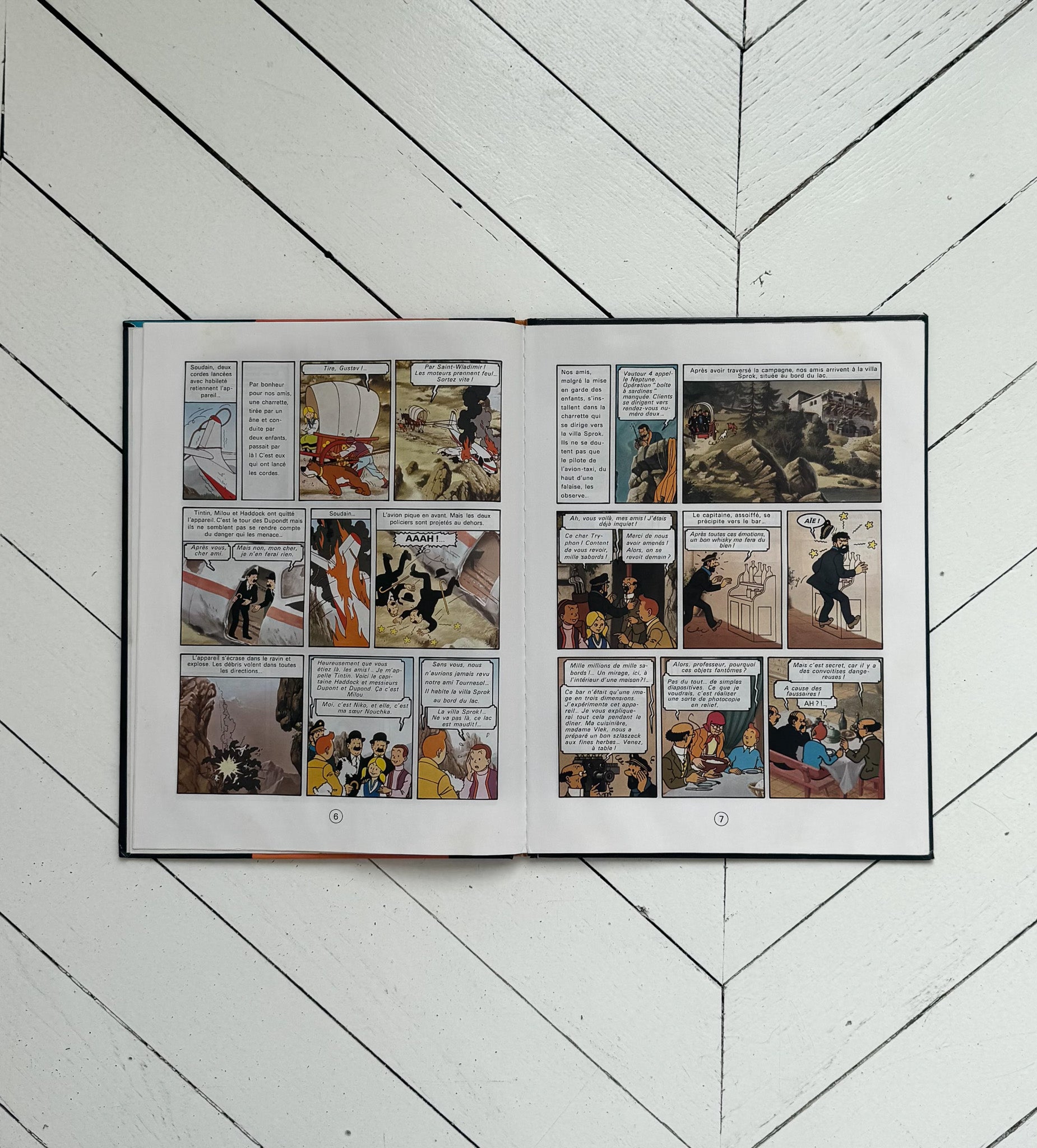 Open comic book on a white wooden floor