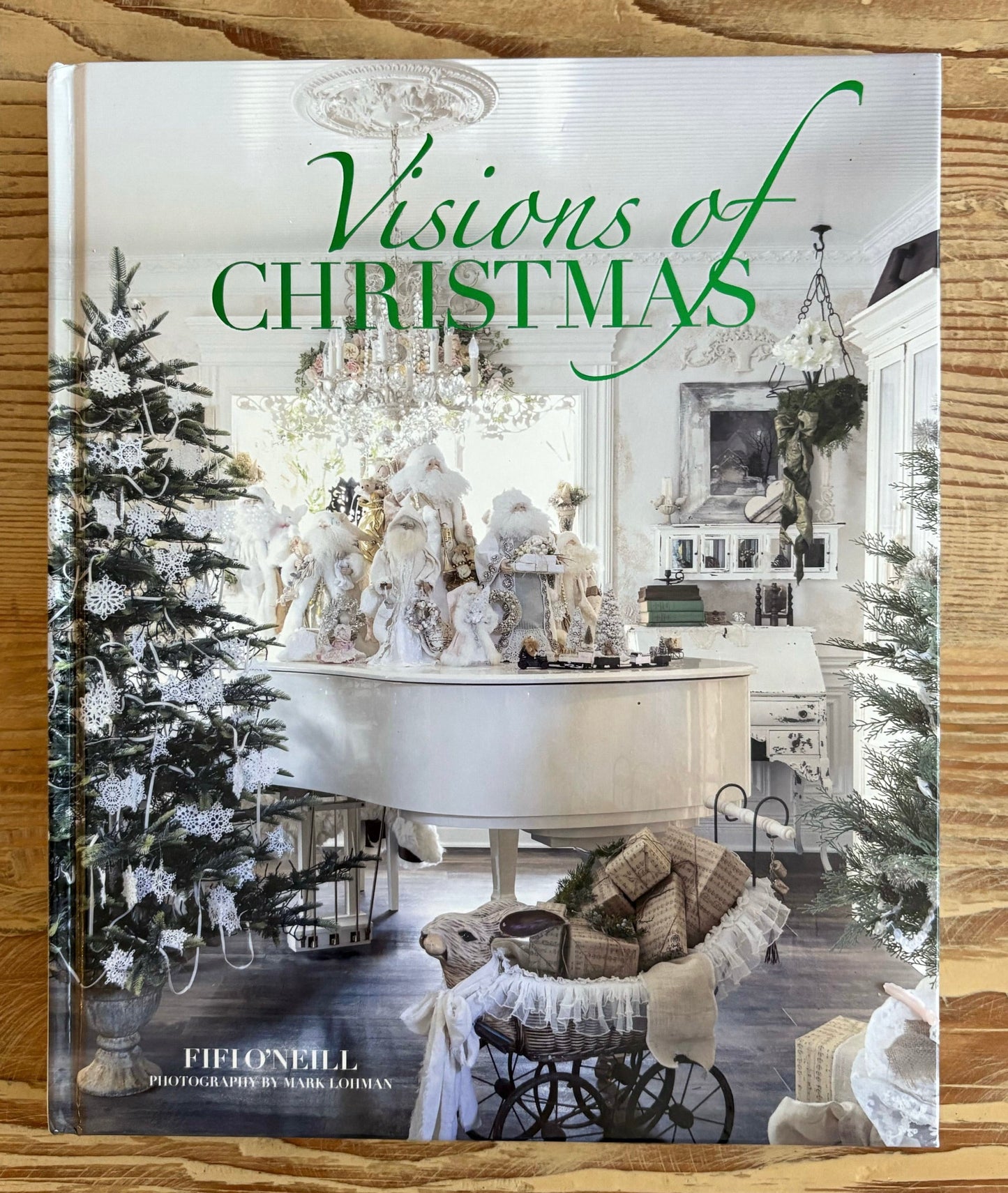 Book titled 'Visions of Christmas' on a wooden surface