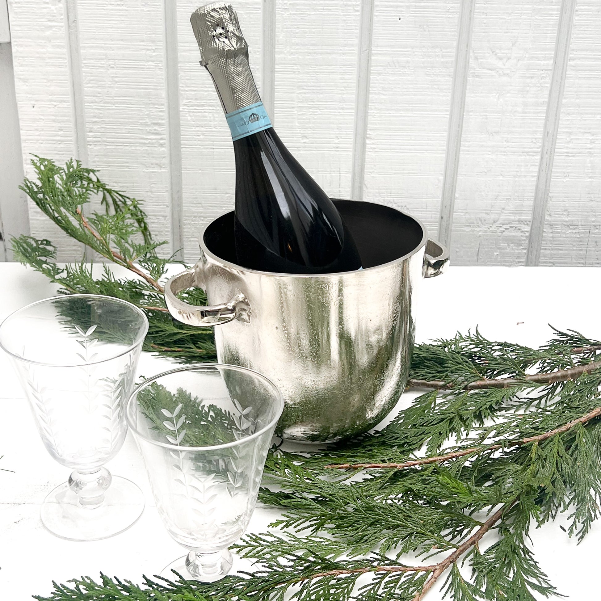 silver metal ice bucket with two handles and a lid