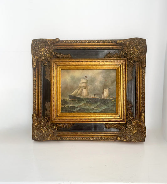 Decorative gold frame with a painting of ships on water