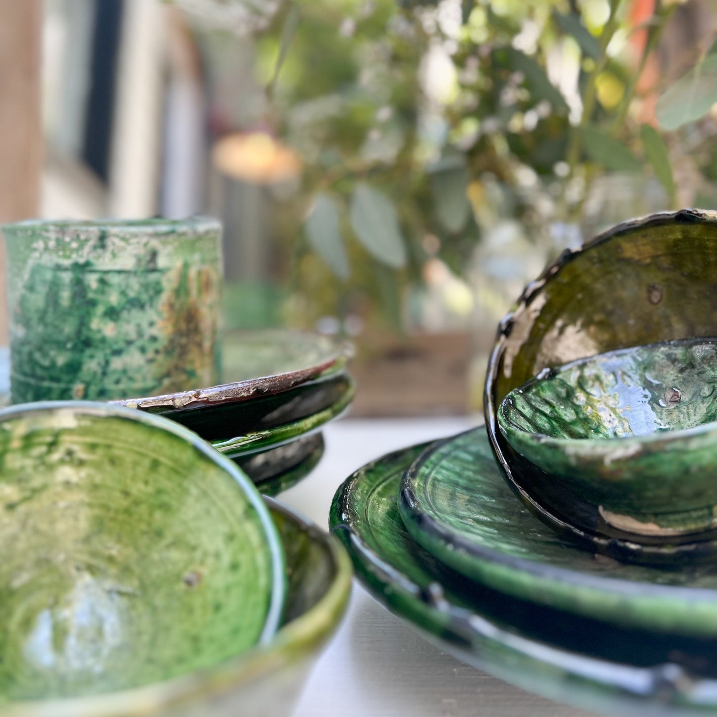 rustic ceramic handmade bowl in varying shapes and sizes with green glaze