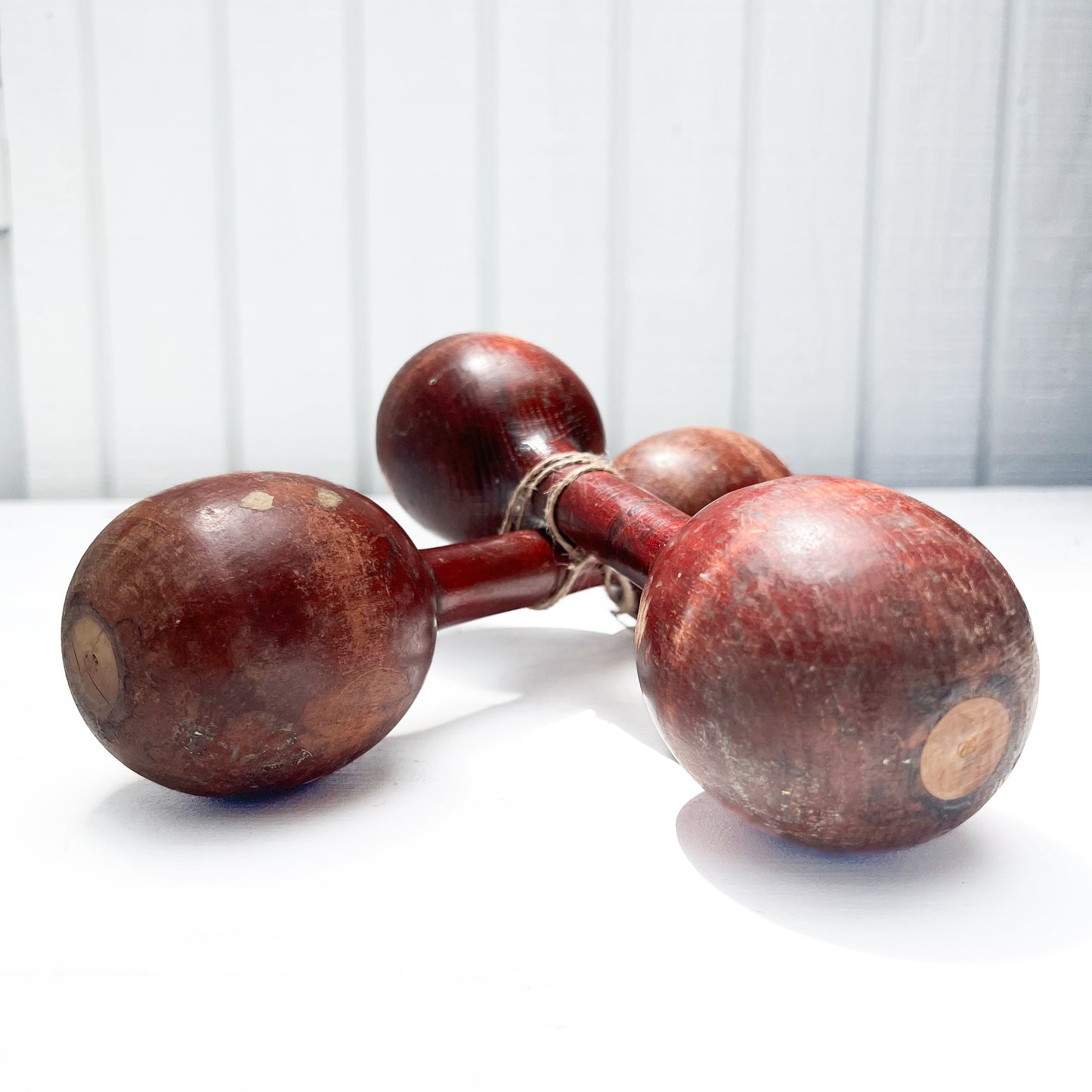 vintage wooden hand held dumbbells in cherrywood color with some aging.