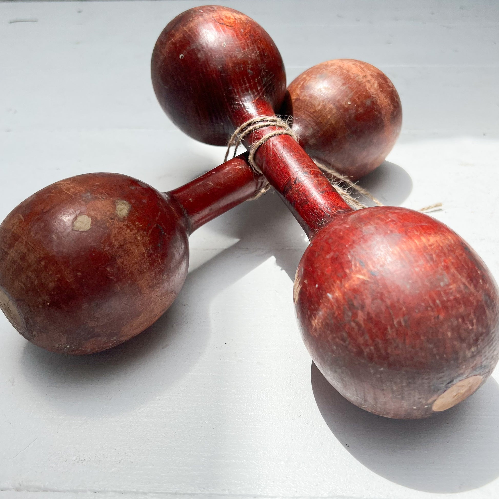 vintage wooden hand held dumbbells in cherrywood color with some aging.