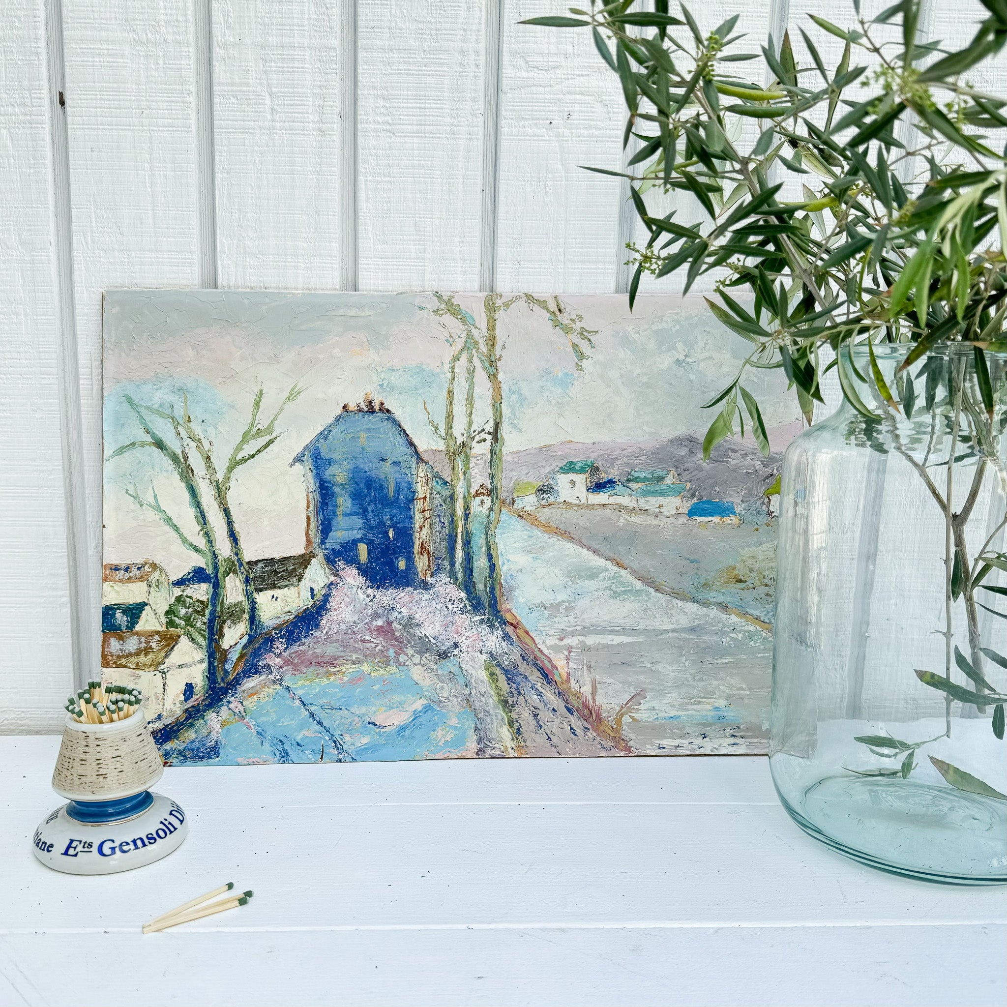 Mostly pastel colored French countryside scene with cobalt blue building