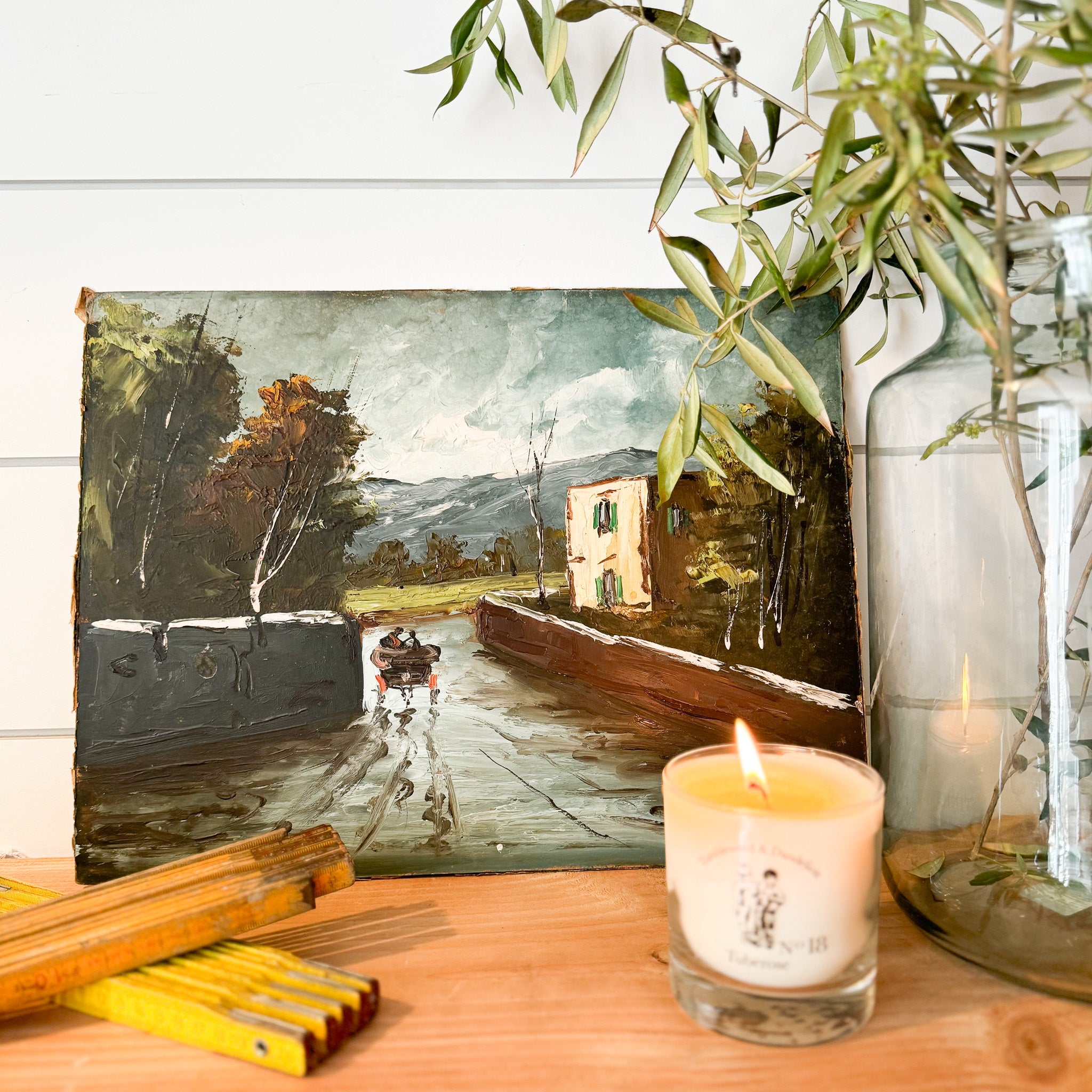 Vintage painting of two people in a boat on narrow river with mountains in the background