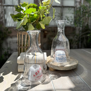 clear glass carafes with dome bottoms that have text in French in red and blue