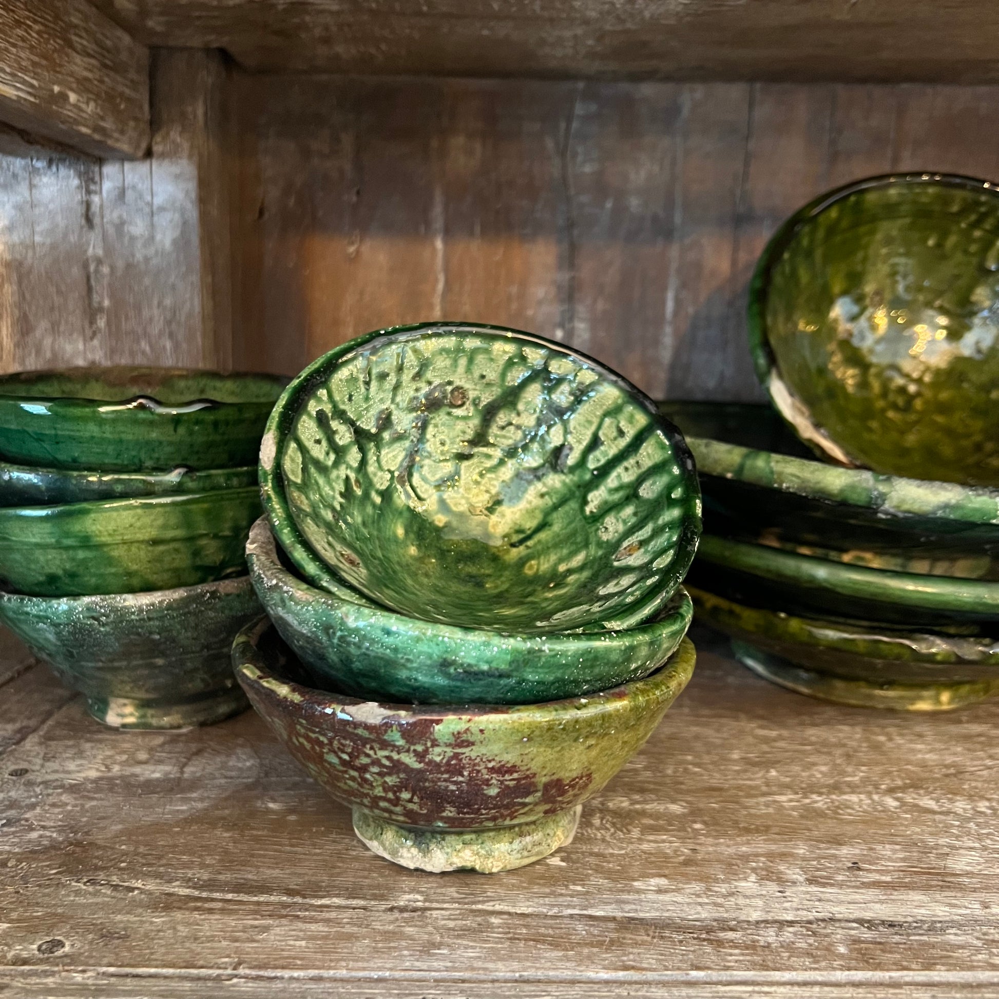 rustic ceramic handmade bowl in varying shapes and sizes with green glaze