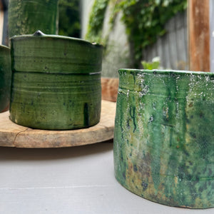 handmade rustic clay cylindrical mug with green glaze and no handle