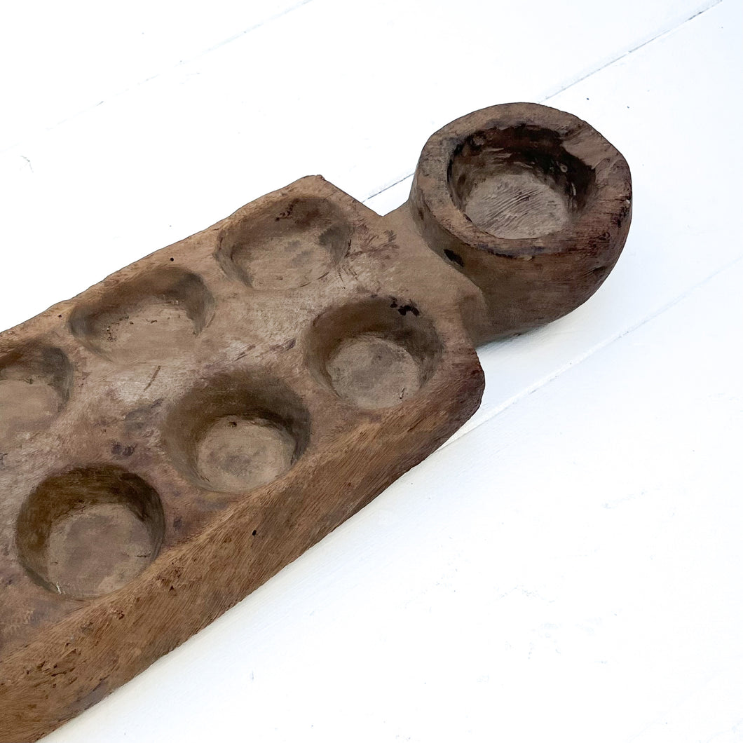 long wooden brown board with hollowed out cups