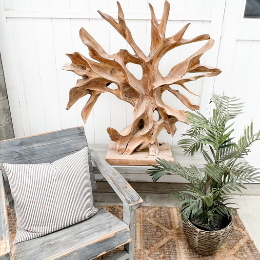large abstract carved wooden sculpture, somewhat of a resemblance to a bare tree, black base