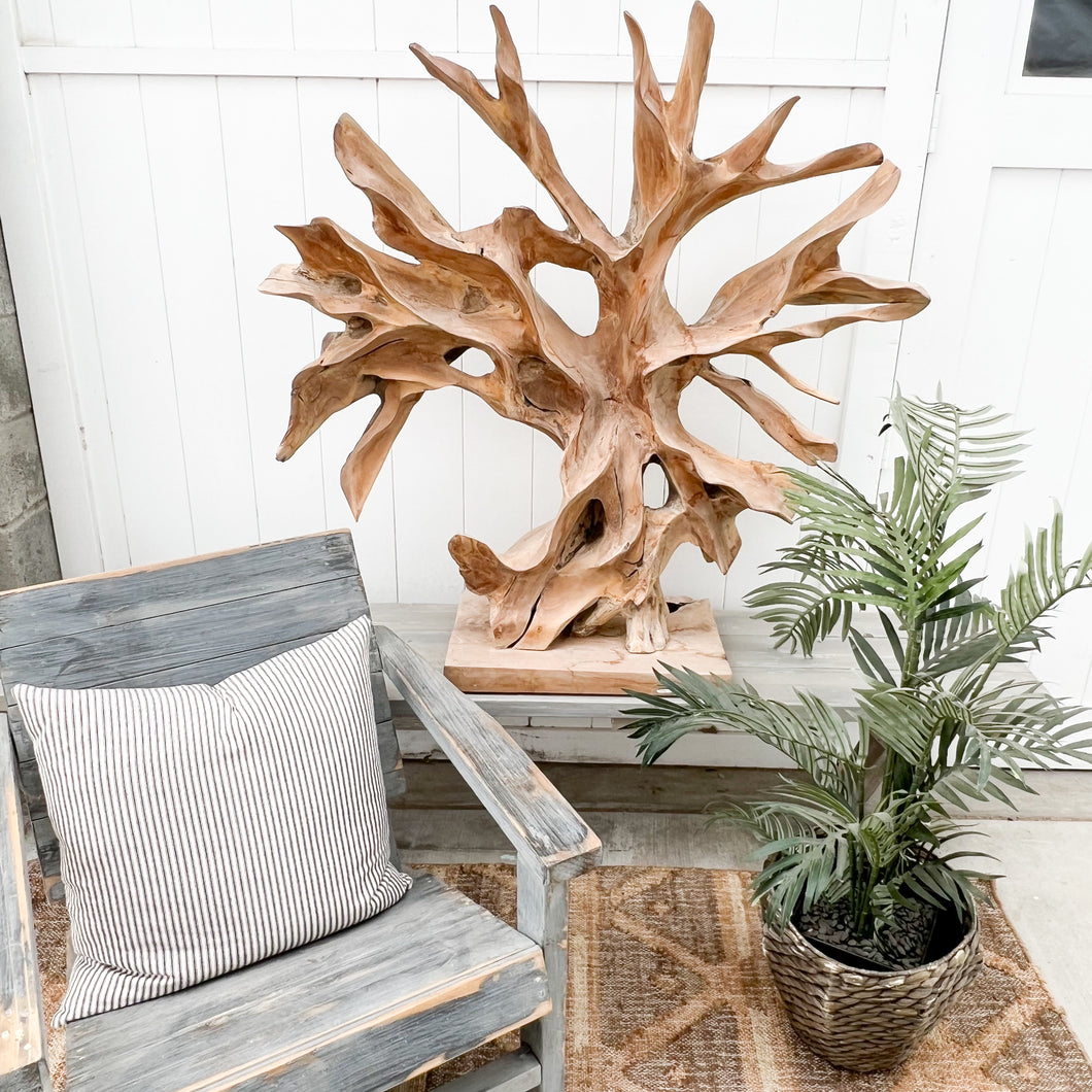 large abstract carved wooden sculpture, somewhat of a resemblance to a bare tree, black base