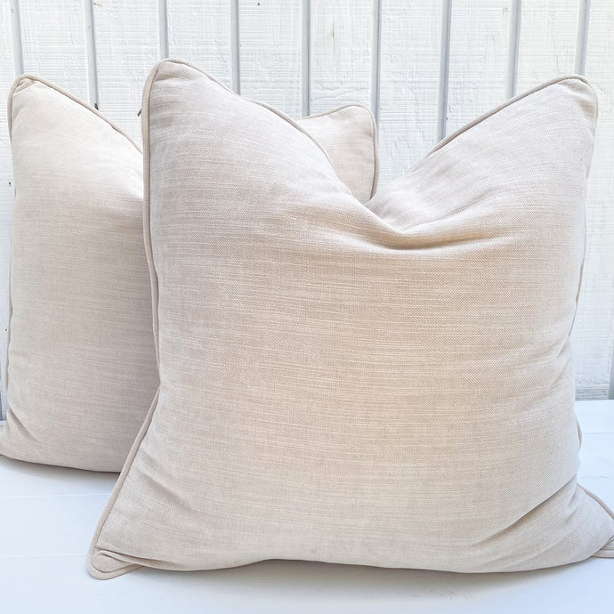 beige colored square pillows with piping