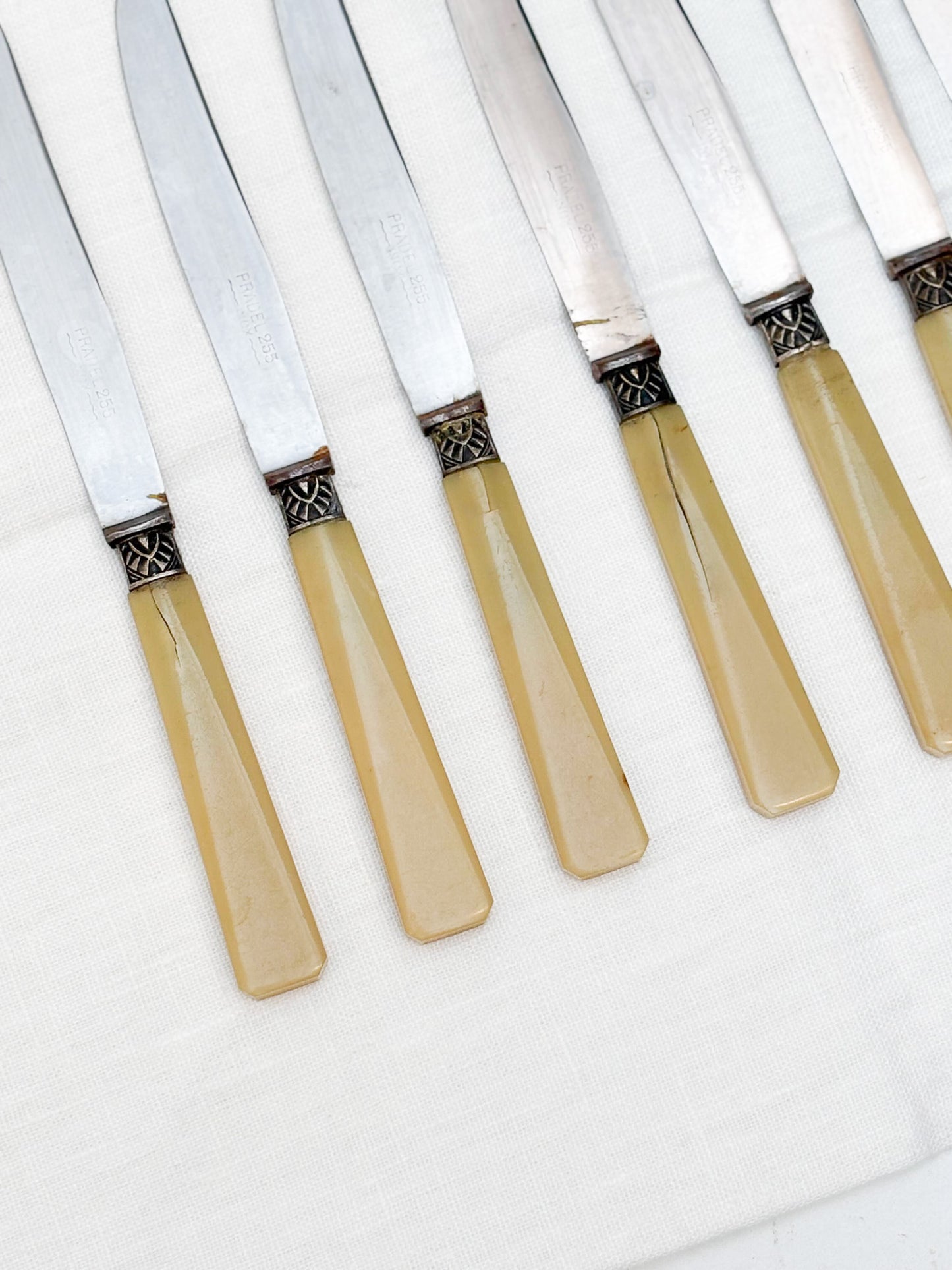 Set of six knives with beige handles on a white background