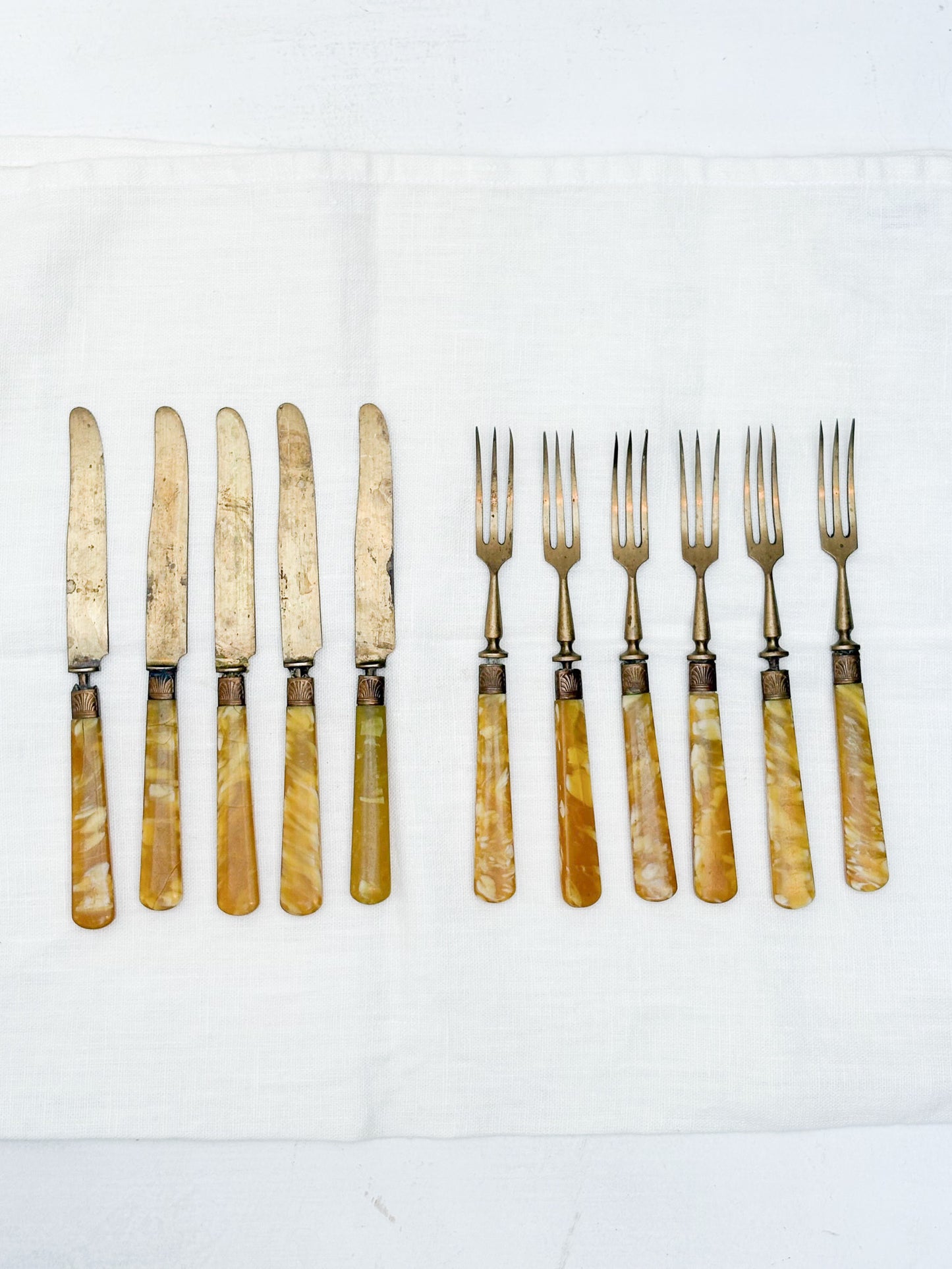 Set of knives and forks with pearlized handles on a white background