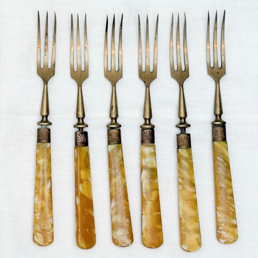 Set of six vintage forks with decorative handles on a white background