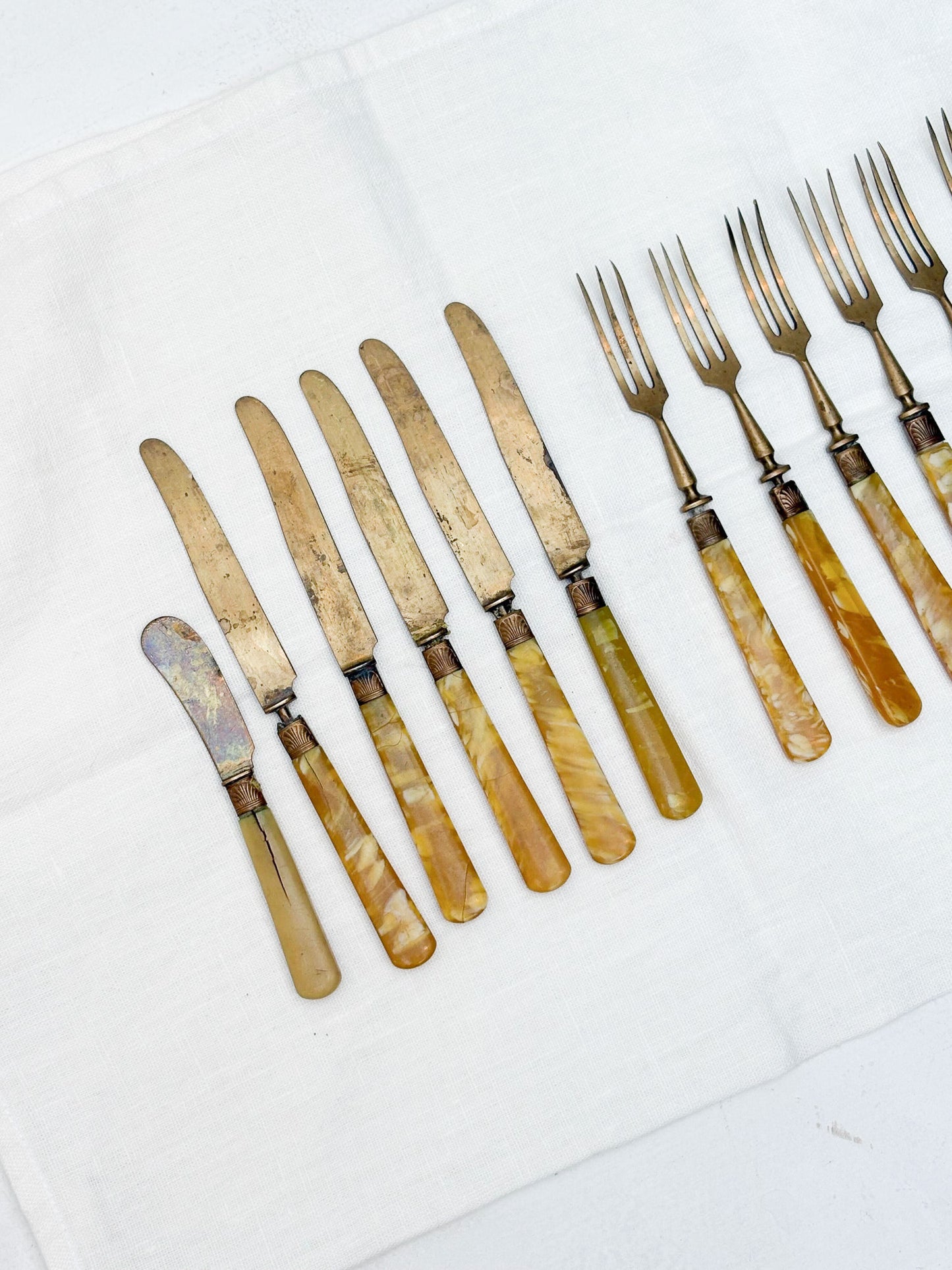 Set of vintage knives and forks with pearlized handles on a white background