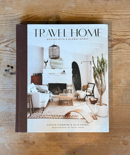 Book titled 'Travel Home' on a wooden surface