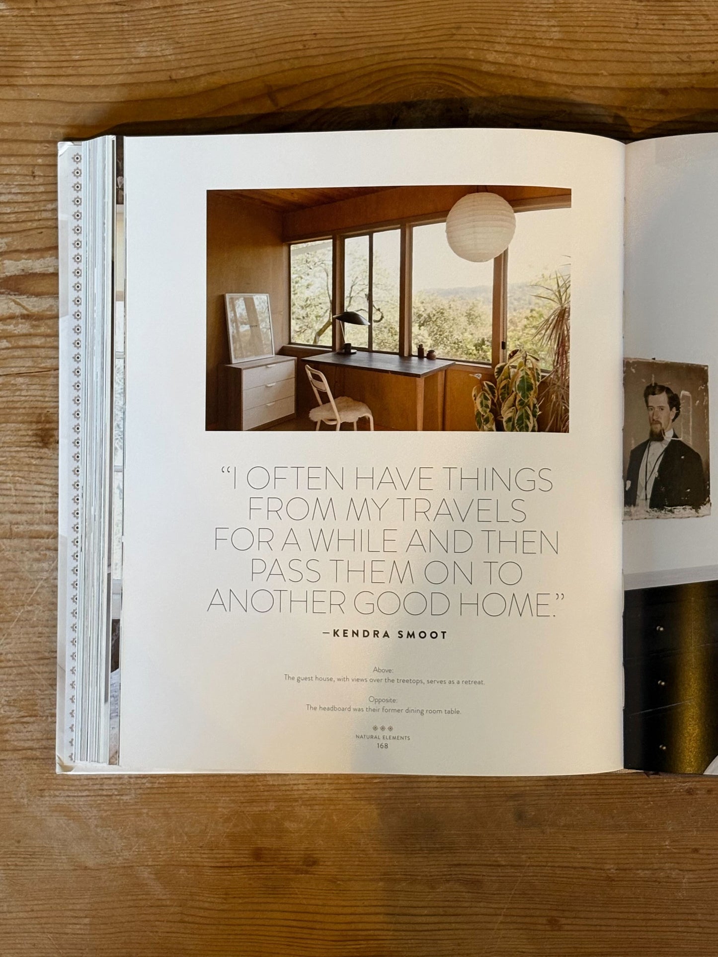 Open book on a wooden surface with interior design imagery and text.