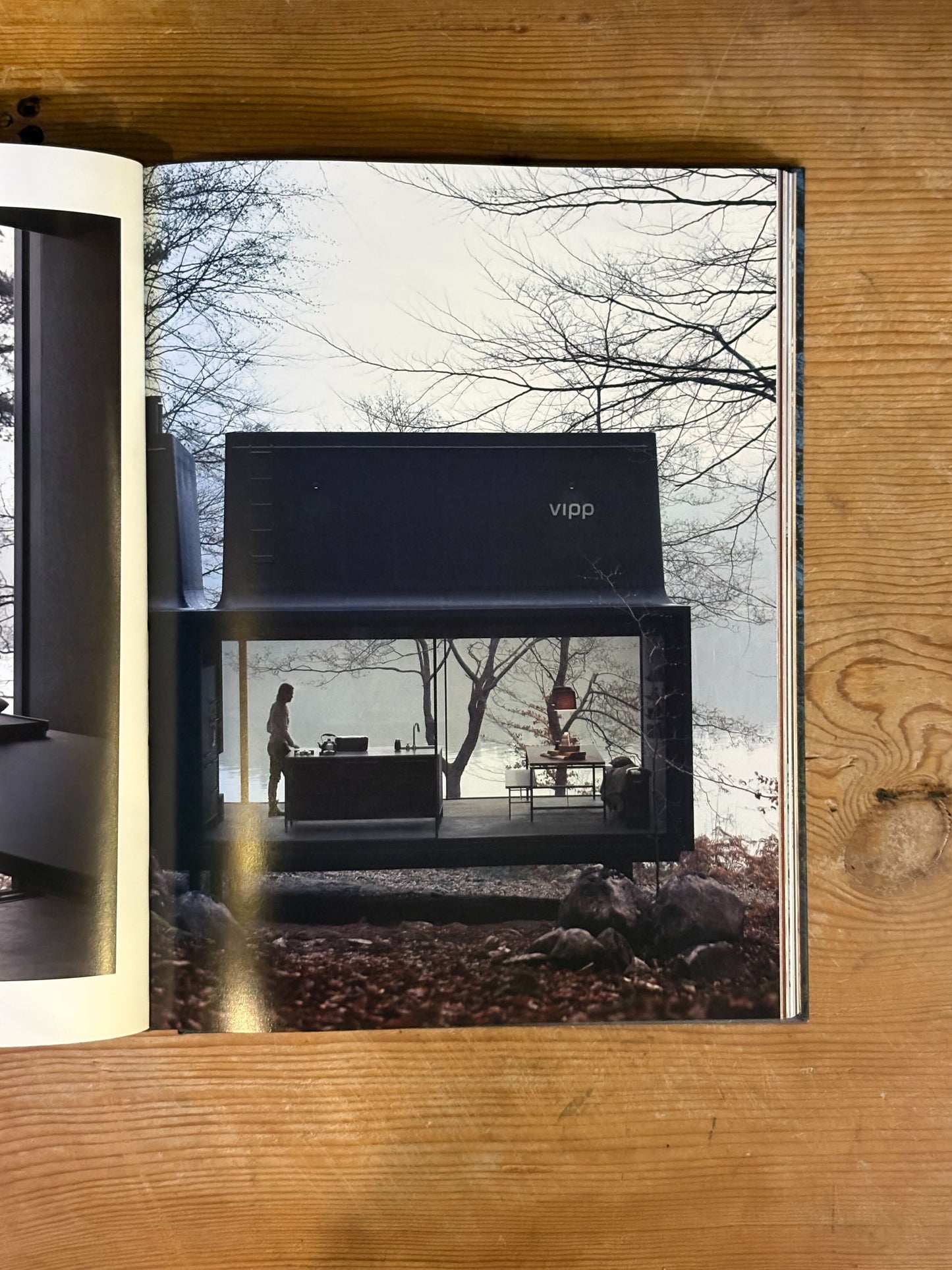 Open book with a photograph of a modern house exterior on a wooden surface