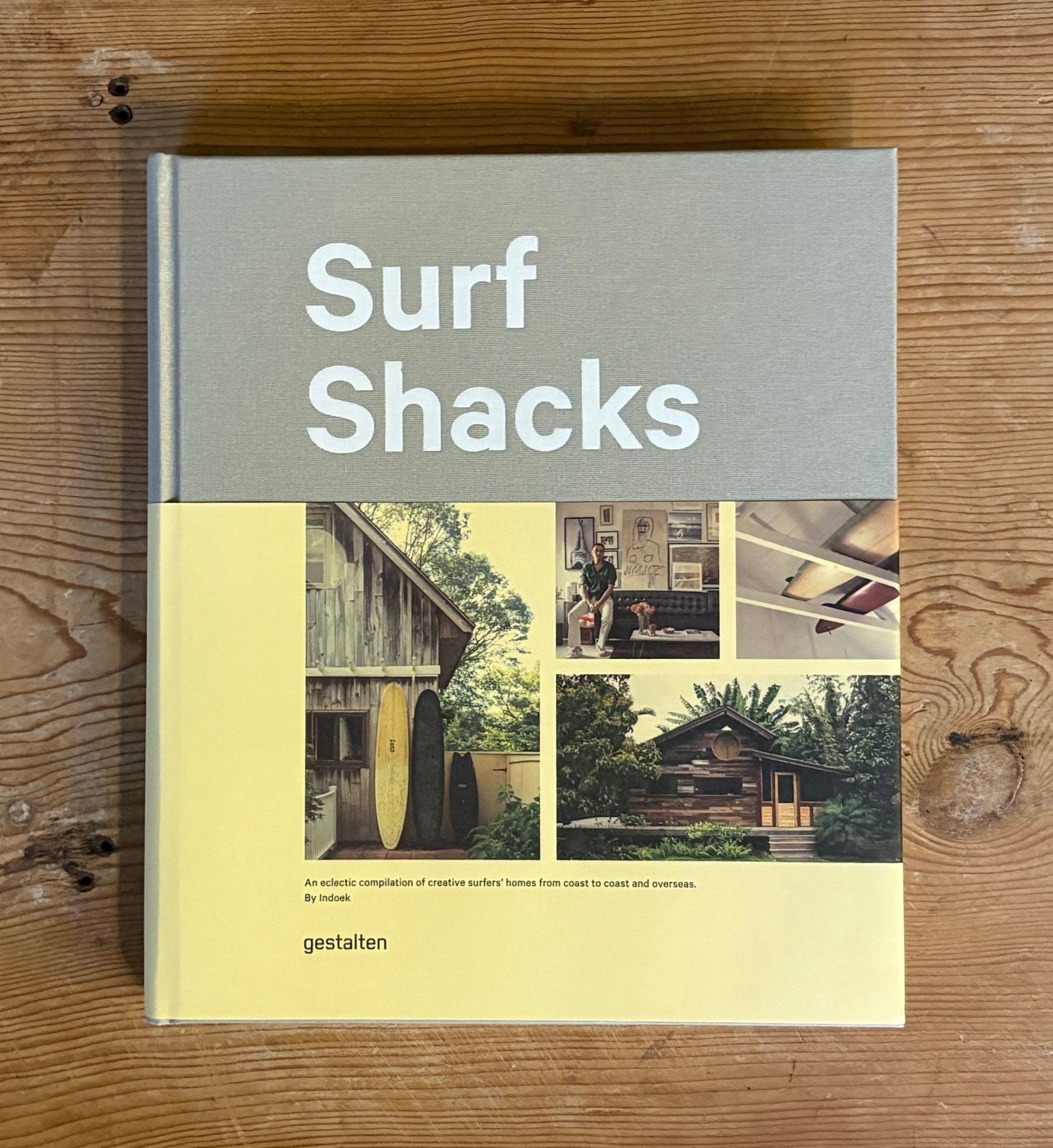 Book titled 'Surf Shacks' on a wooden surface