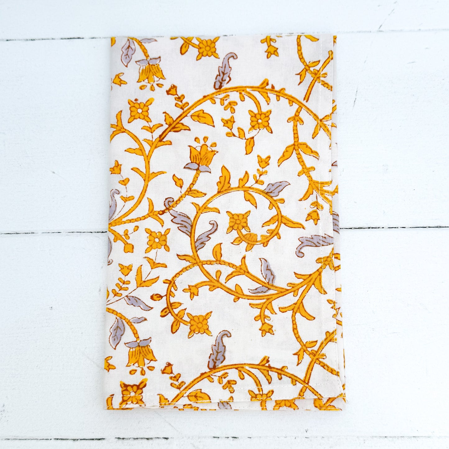 white cotton napkin with amber and gray vine pattern