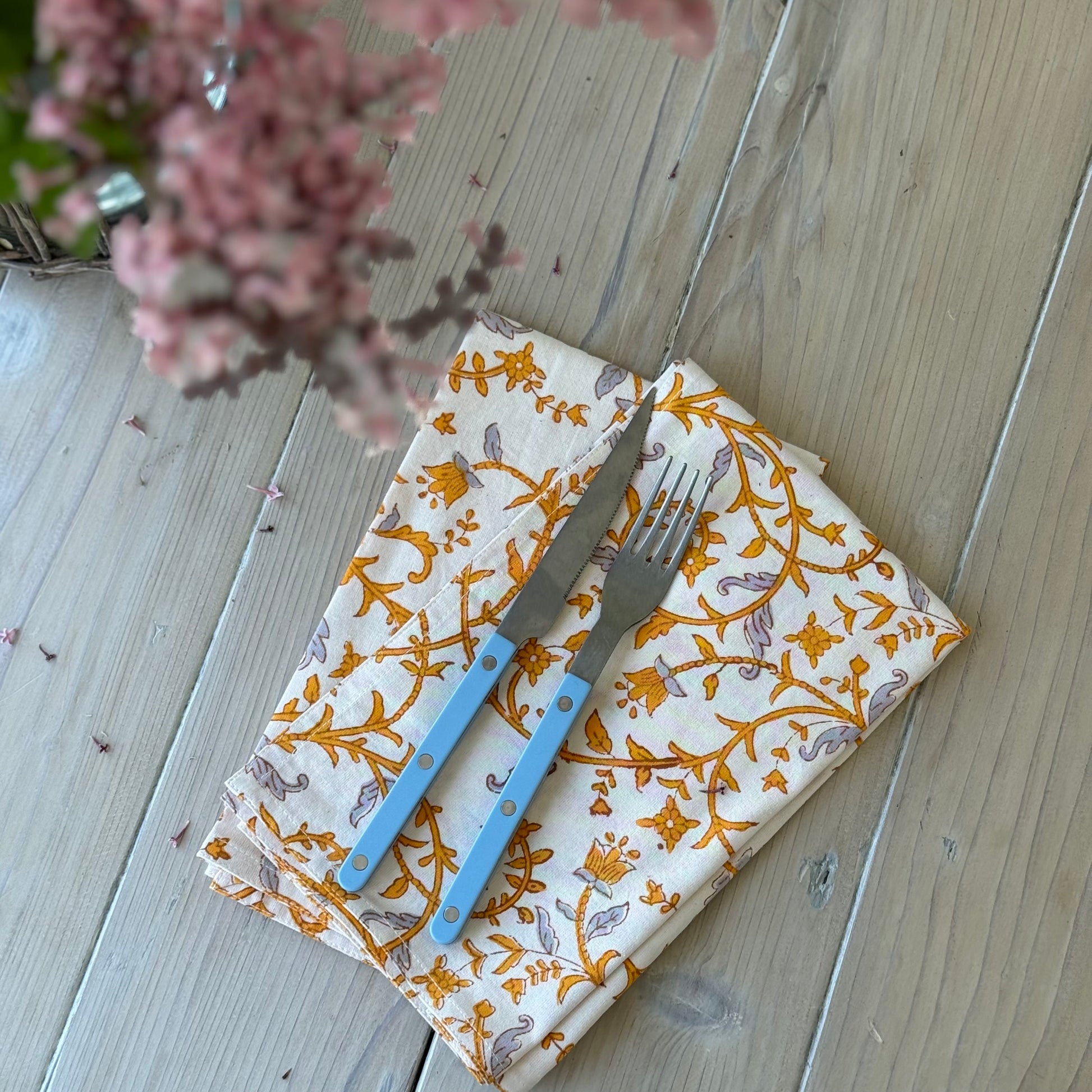 white cotton napkin with amber and gray vine pattern