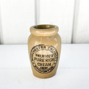 tan colored vintage ceramic jar with black text
