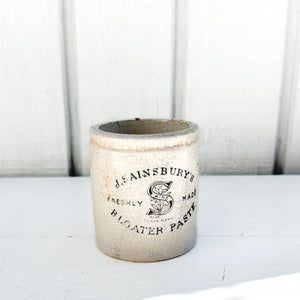 off white vintage crackled ceramic jar with black text 