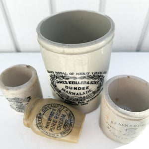 tan colored vintage ceramic jar with black text