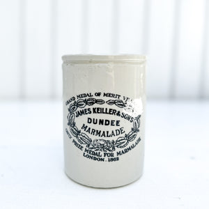 vintage off white ceramic canister with black logo and text