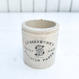 off white vintage crackled ceramic jar with black text 