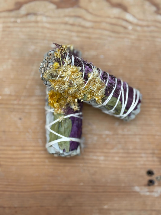 Decorative letter 'P' with gold and purple elements on a wooden surface