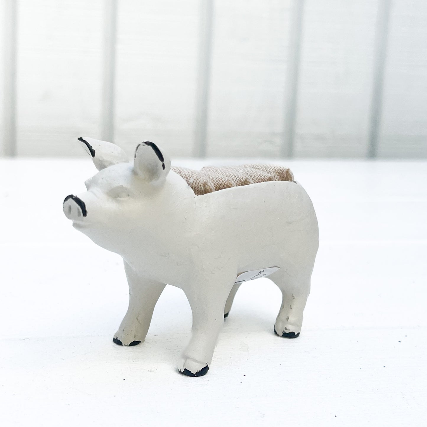white metal pig ring holder, with burlap slots on top for rings