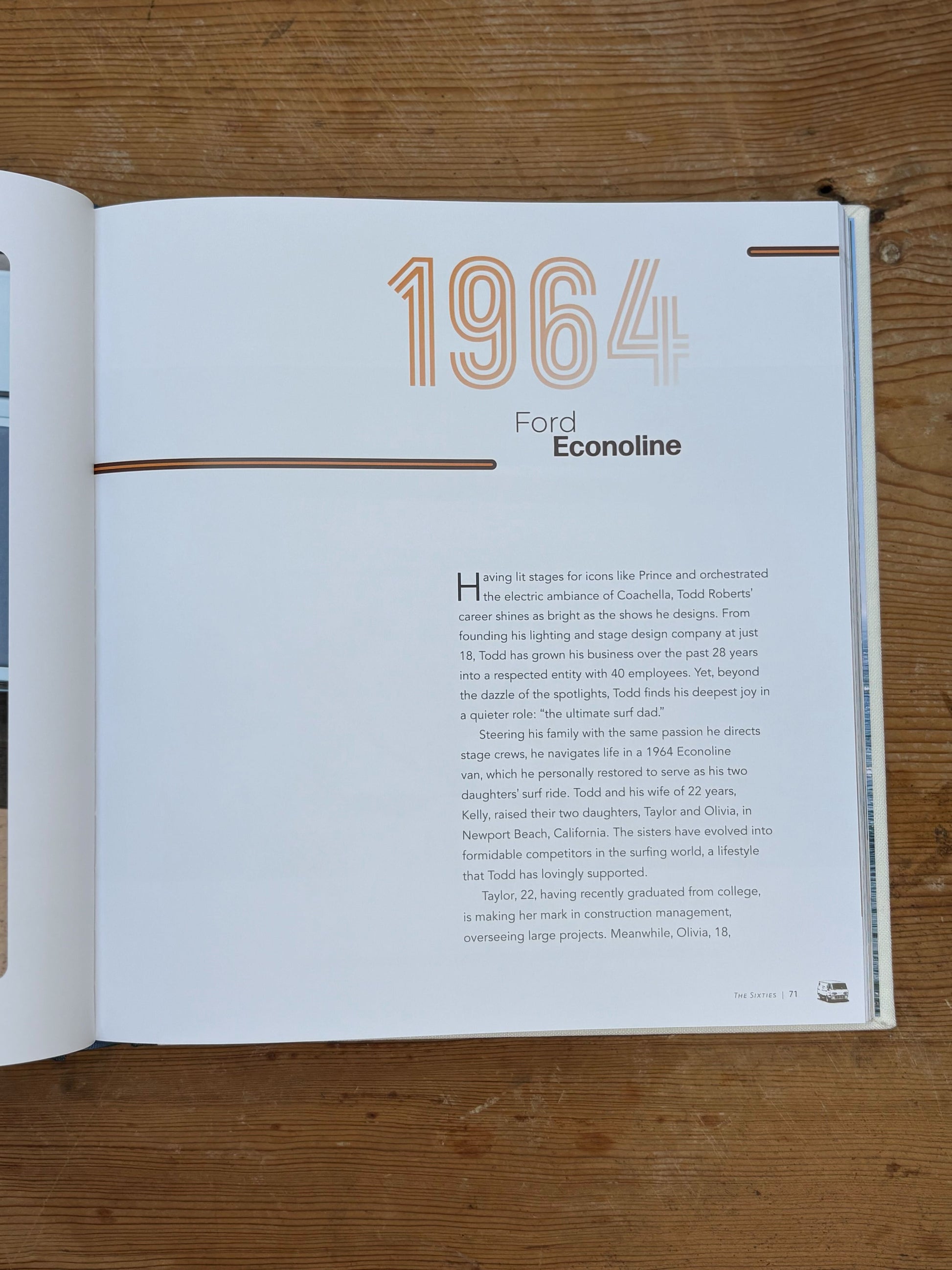 Open book showing a page with '1964 Ford Econoline' text on a wooden surface