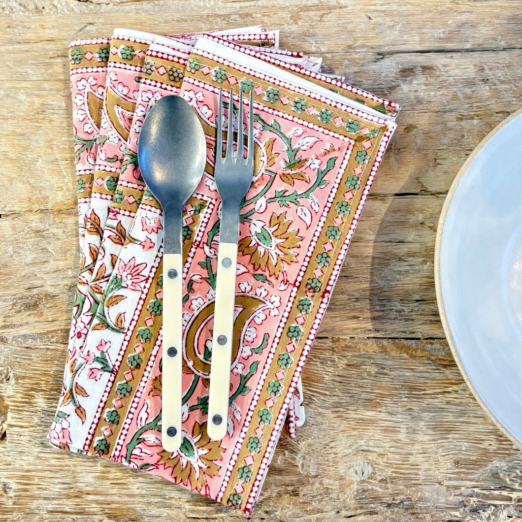 Patterned napkin with a spoon and fork on a wooden table