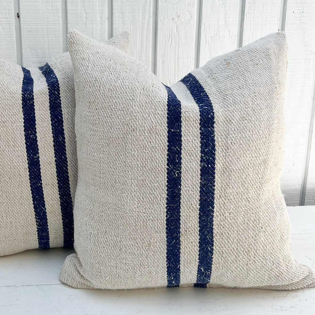 off white grain sack fabric pillow with two navy vertical stripes down the middle