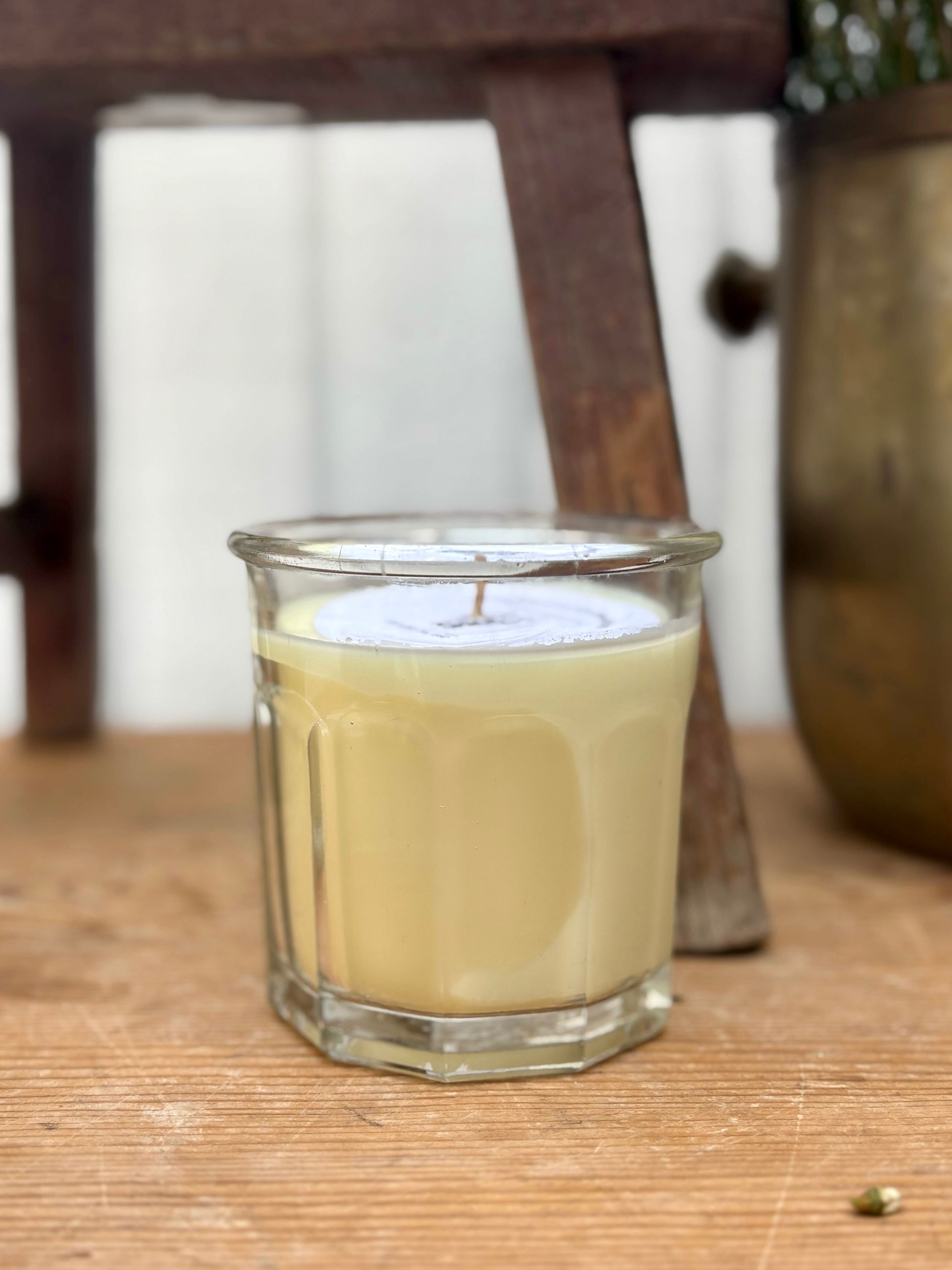 Glass candle with a wooden base and blurred background