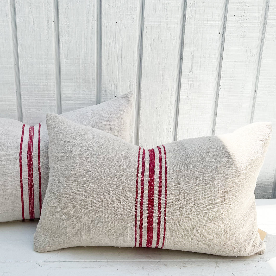 grain sack fabric lumbar pillow with red stripes down the middle