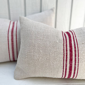 off white grain sack fabric lumbar pillow with red stripes down the middle