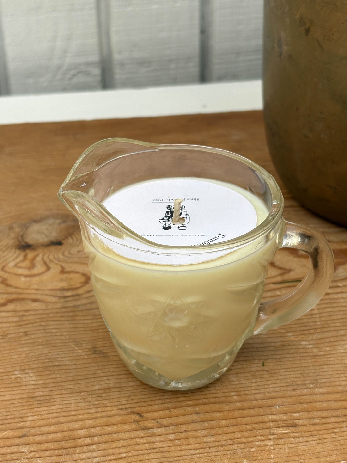 Glass pitcher filled with a liquid on a wooden surface