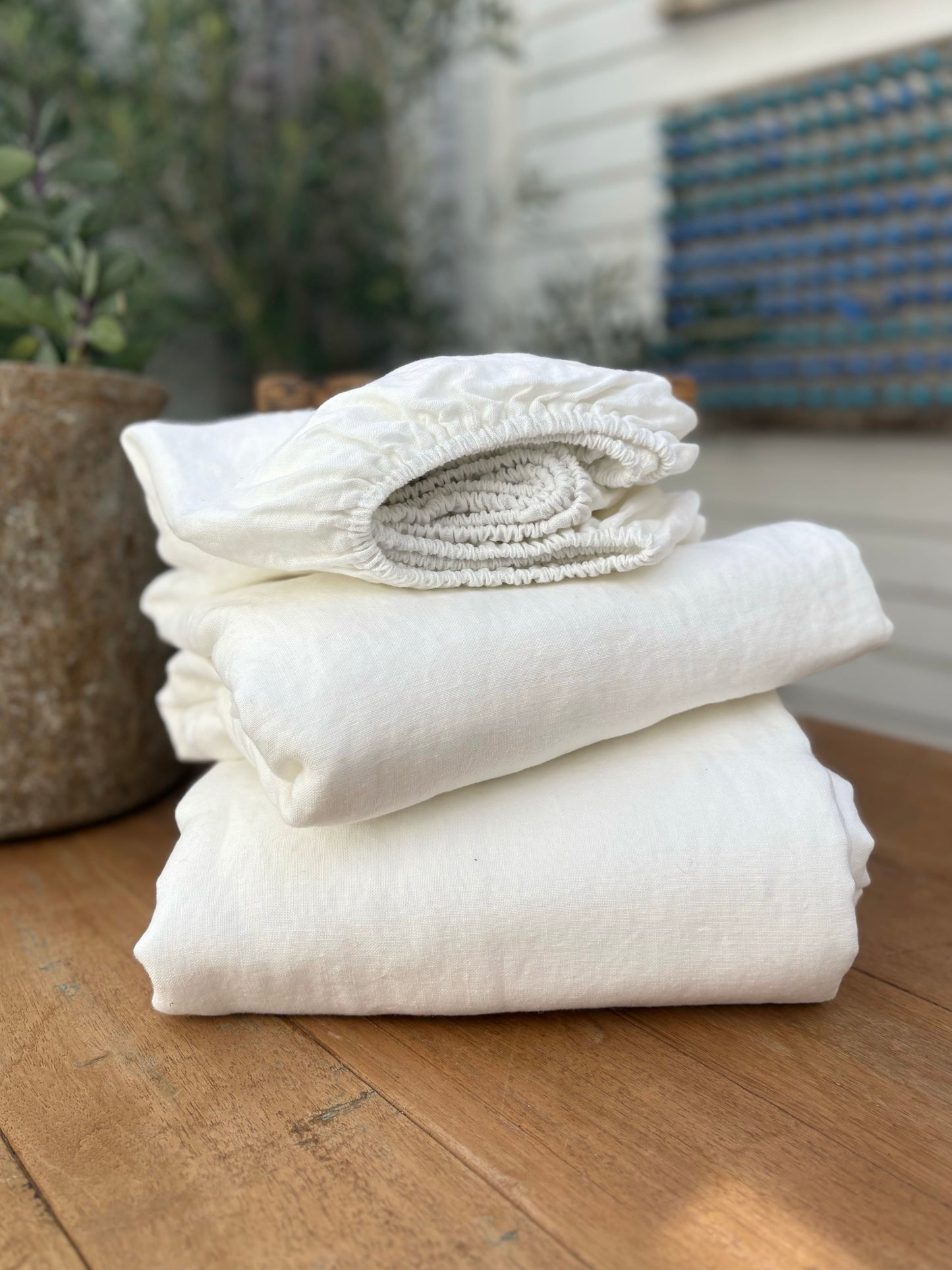Stack of white towels on a wooden surface with a blurred background