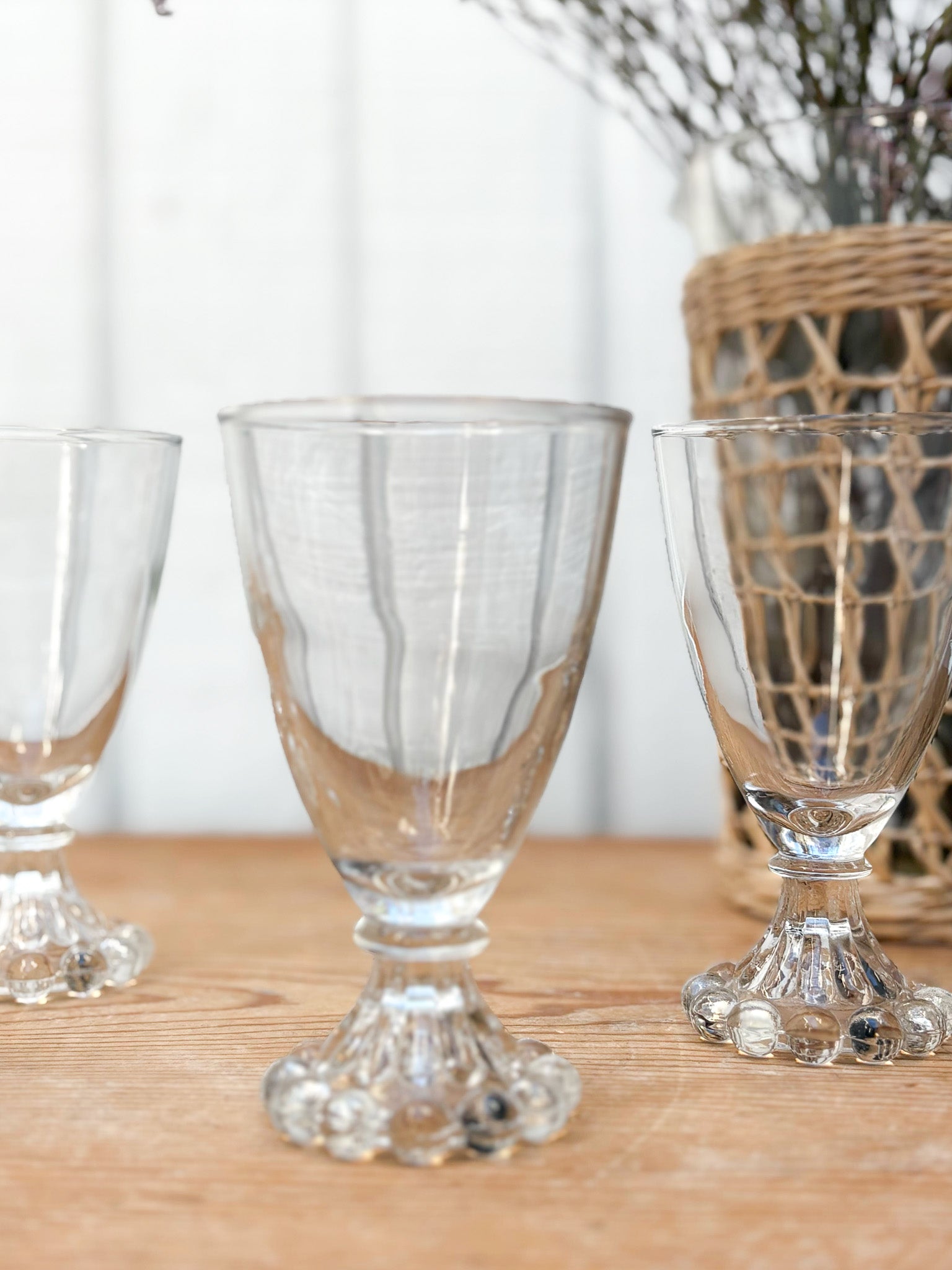 Clear glass goblets on a wooden surface with a blurred background