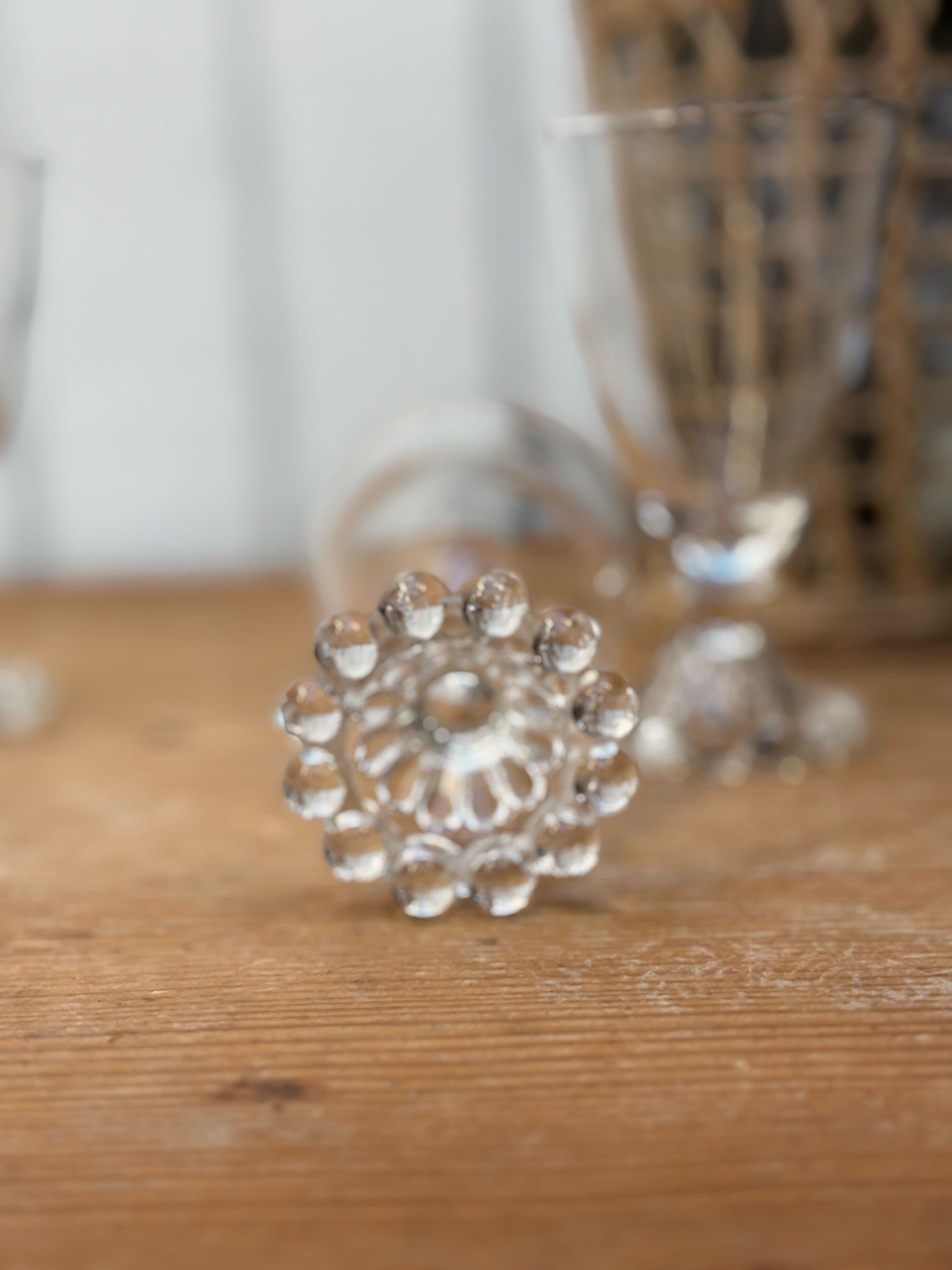 Decorative glass knob on a wooden surface with a blurred background