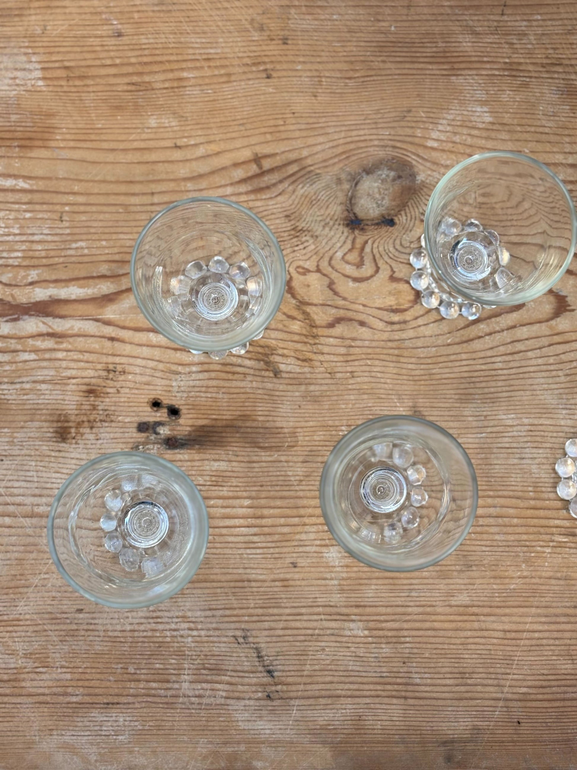 Four clear glass tumblers on a wooden surface