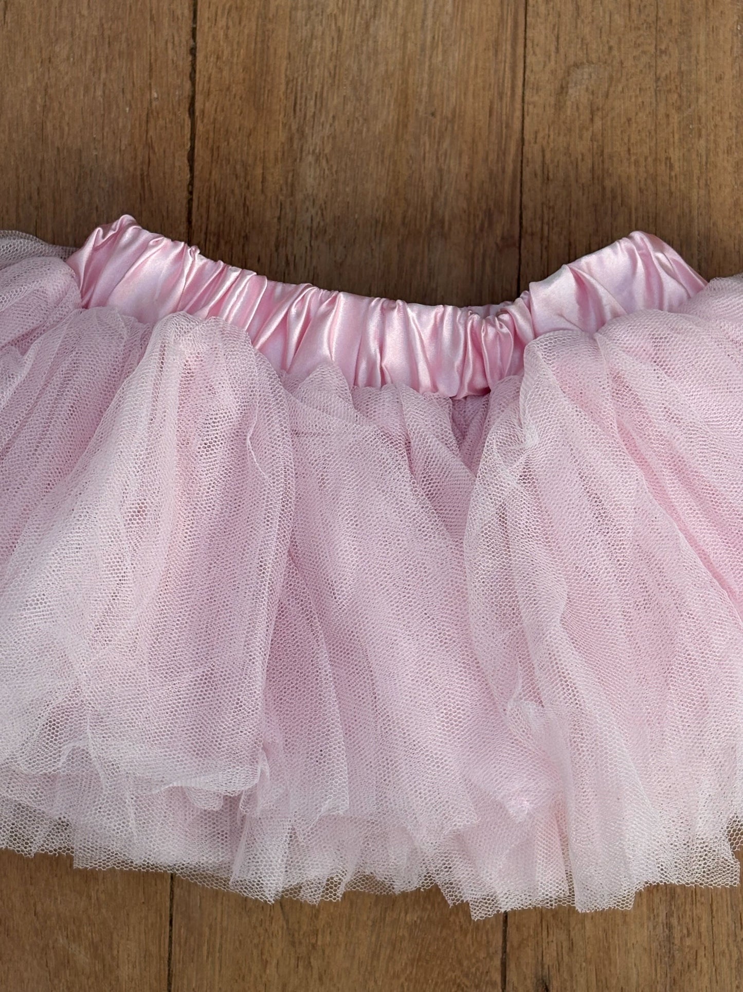 Pink tutu skirt on a wooden surface