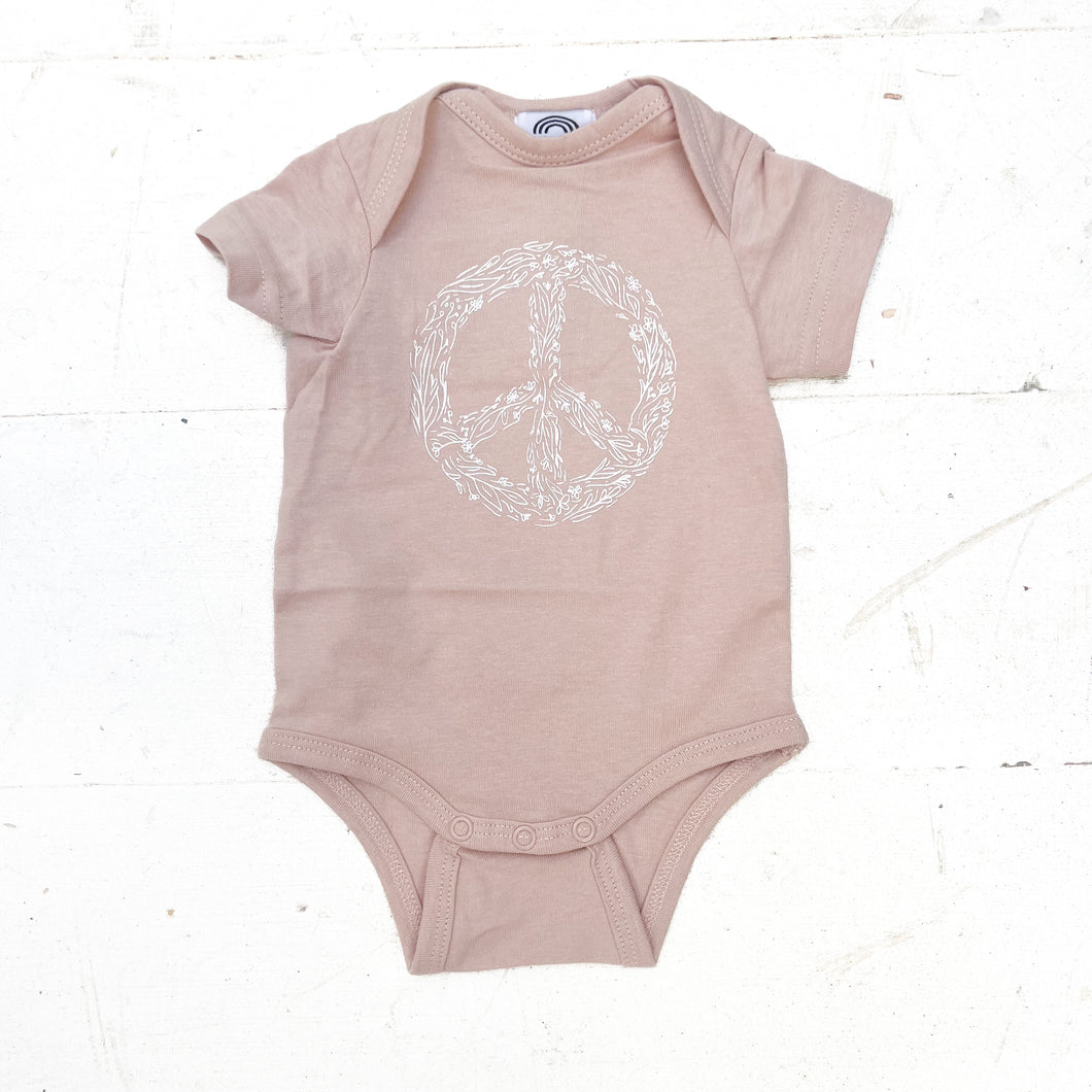 light pink onesie with white floral peace sign
