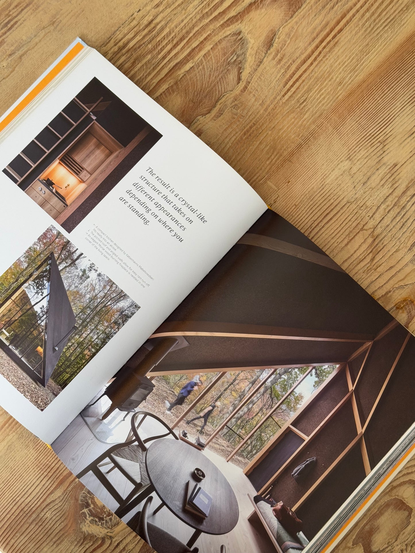Open book showing interior design images on a wooden surface