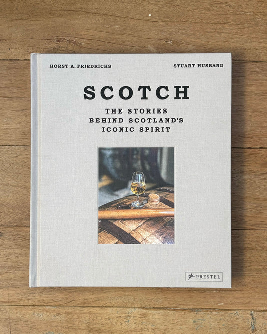 Book titled 'Scotch: The Stories Behind Scotland's Iconic Spirit' on a wooden surface